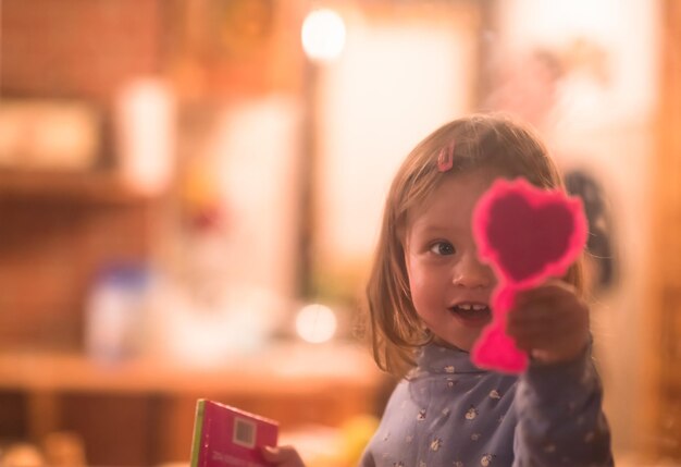 Foto una niña linda jugando cerca de la ventana