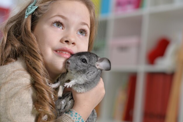 Niña linda jugando con chinchilla