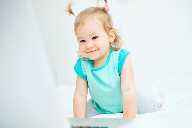 Niña linda jugando en una computadora portátil