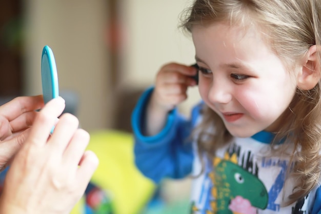 Niña linda jugando con cosméticos en casa