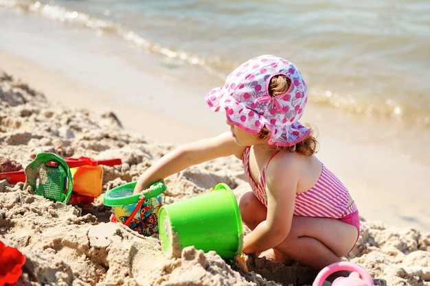 Niña linda jugando en la playa