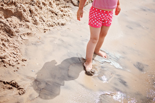 Niña linda jugando en la playa