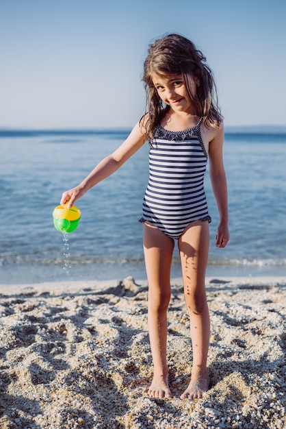 Niña linda jugando en la playa