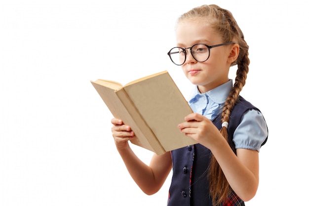 Niña linda lee un libro mientras usa gafas, aislado en blanco