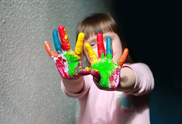 Niña linda con las manos pintadas.