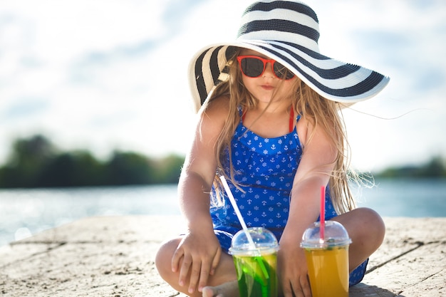 Niña linda en el mar. Chica del sombrero en verano. Adorable niño en la costa.