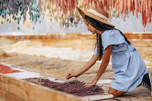 Niña linda con mazorcas de maíz secas decorativas y pajitas