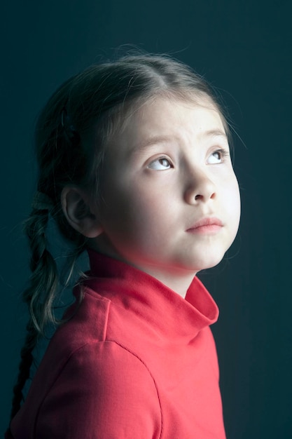 Niña linda mirando hacia arriba pensativamente