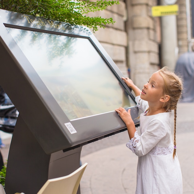 Niña linda mirando el mapa de Milán