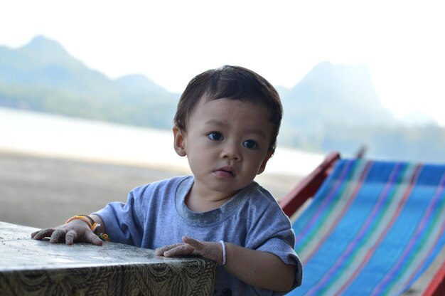 Foto una niña linda mirando hacia la playa.