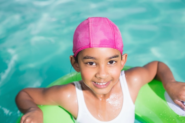 Niña linda nadando en la piscina