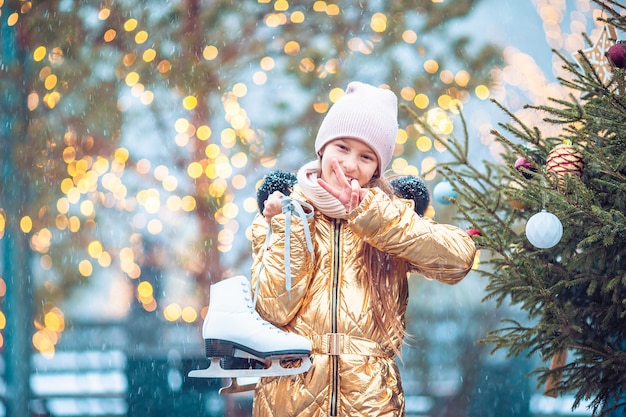 La niña linda del niño va a patinar al aire libre.