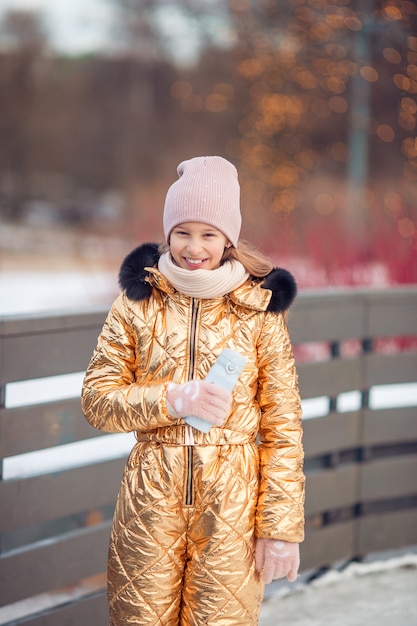 La niña linda del niño va a patinar al aire libre.