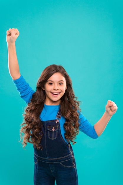 Foto niña linda niño pelo largo y rizado feliz sonriente psicología y desarrollo infantil ganador feliz celebrar la victoria o el logro niño feliz exitoso lograr el éxito niño alegre celebrar la victoria