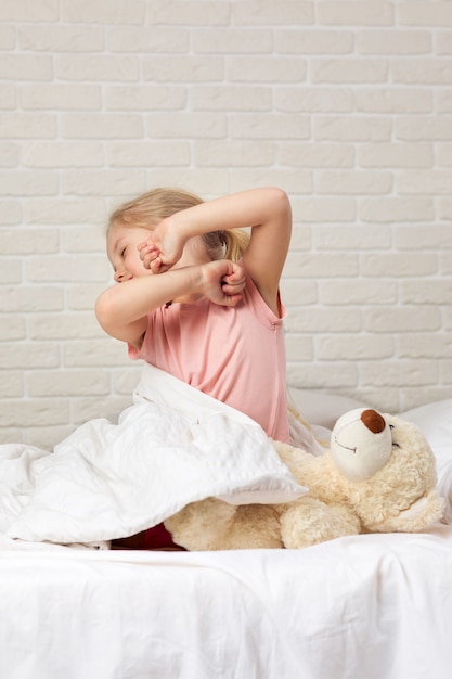 La niña linda del niño pequeño se despierta de sueño