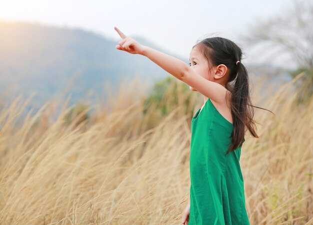 Niña linda del niño que destaca en el campo del verano al aire libre