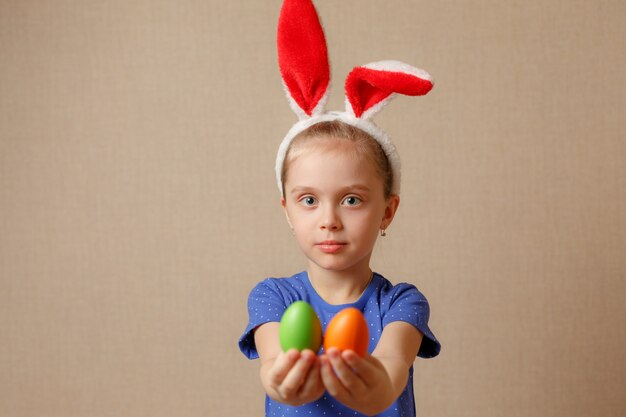 Niña linda con orejas de conejo y huevos de Pascua. enfoque selectivo