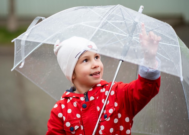 Una niña linda con un paraguas transparente en sus manos