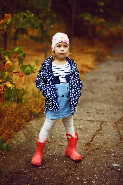 Niña linda en el parque otoño