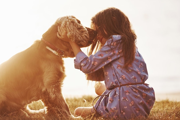 Foto niña linda pasear con su perro al aire libre durante el día