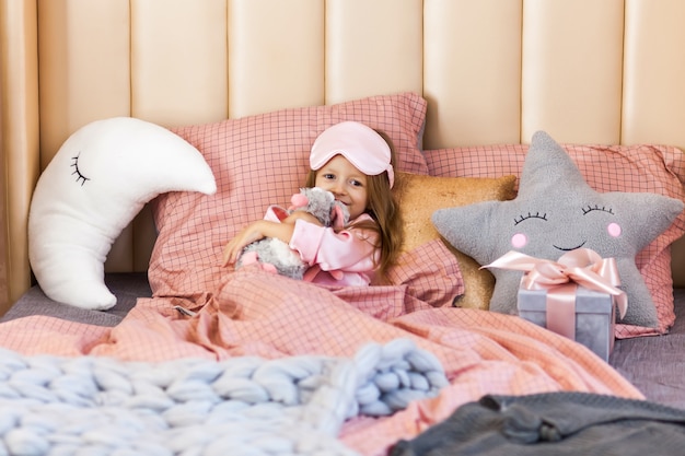 Foto niña linda en pijama en la cama en navidad