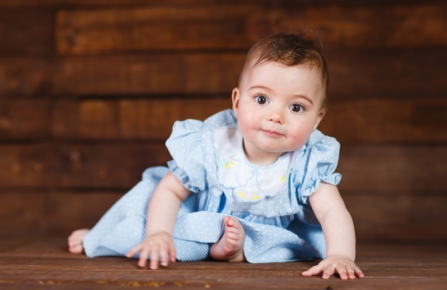 Niña linda en un piso de madera.