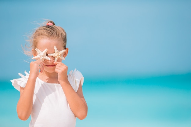 Niña linda en la playa durante las vacaciones de verano