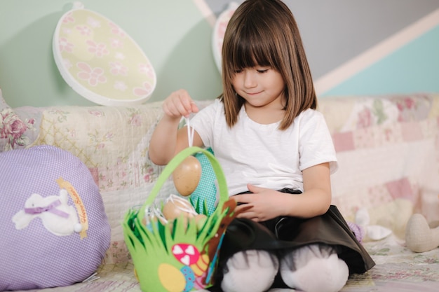 Niña linda preparándose para la pascua durante la cuarentena niña en casa