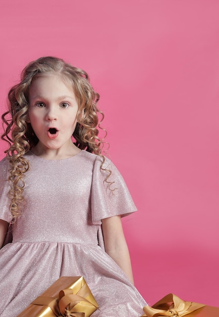 Niña linda con primer plano de regalos, cara sorprendida