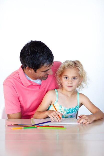 Niña linda que dibuja con su padre