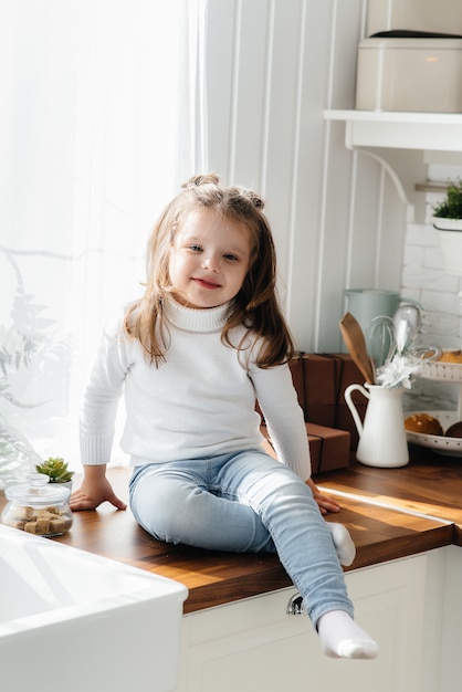 Niña linda que juega en la cocina, felicidad, familia. Cocinando.