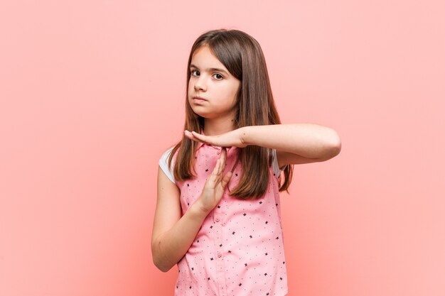 Niña linda que muestra un gesto de tiempo de espera.