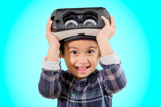 Niña linda que usa gafas de realidad virtual en el estudio