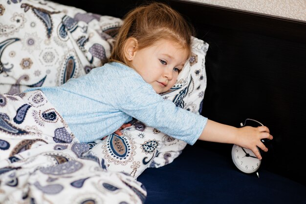 Niña linda quedándose en la cama