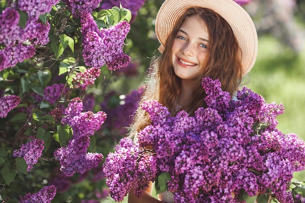 Niña linda con ramo de lilas. Niño adorable al aire libre.