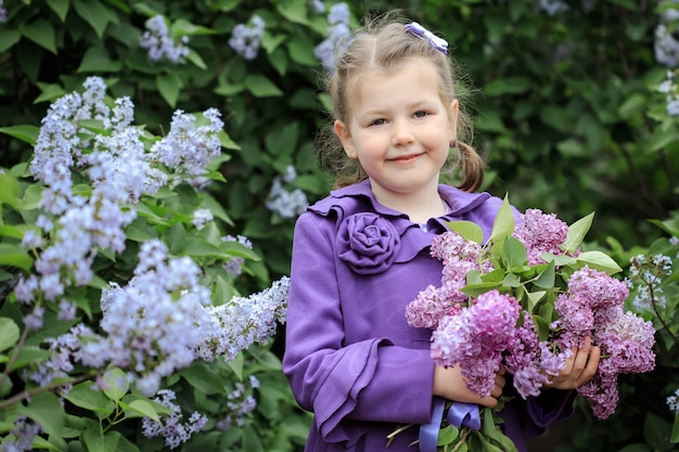 Foto niña linda con un ramo de lilas