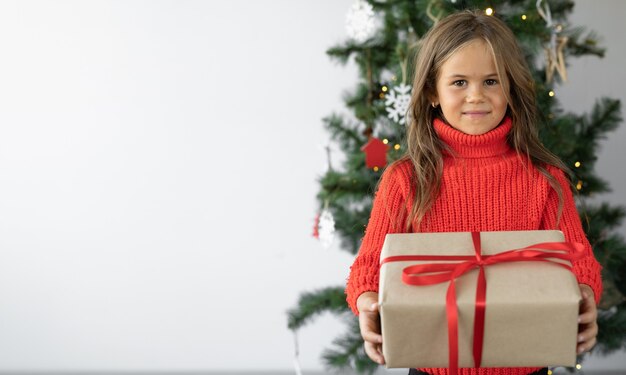 Niña linda con un regalo de Navidad