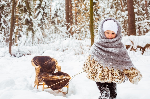 Niña linda en ropa de abrigo en el invierno