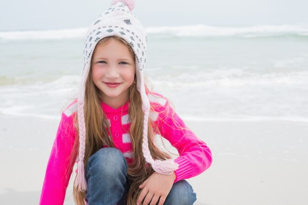 Niña linda en ropa de abrigo en la playa