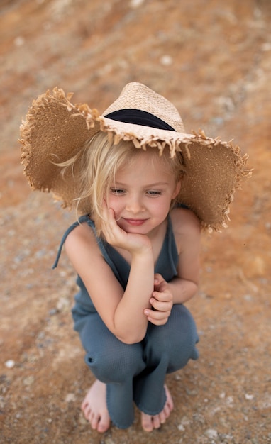 Niña linda en ropa elegante sobre un fondo de rocas