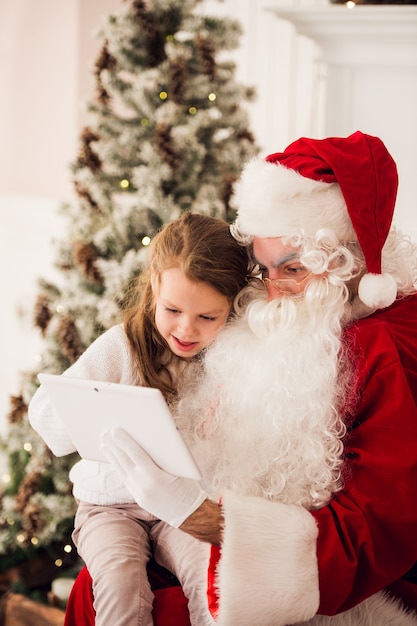 Niña linda con Santa en Navidad en casa