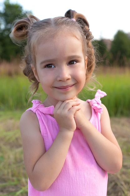 Foto una niña linda está sentada en la hierba en el campo moda belleza verano