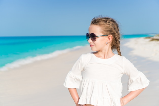 Niña linda con sombrero en la playa durante las vacaciones en el caribe