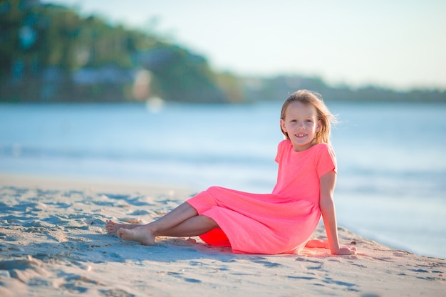 Niña linda con sombrero en la playa durante las vacaciones en el caribe