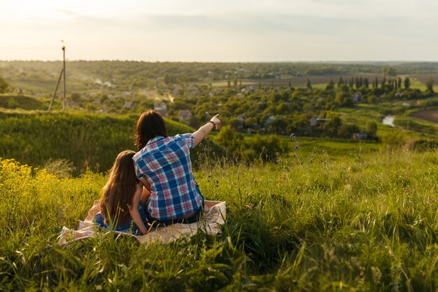 Foto niña linda con su madre sentada al atardecer