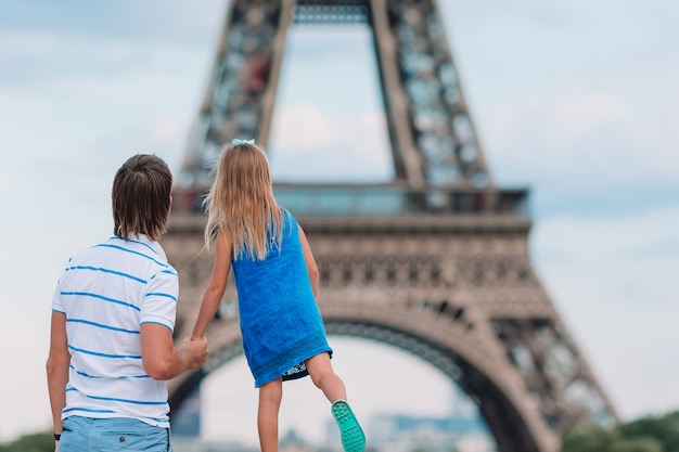 Niña linda y su padre en París cerca de la Torre Eiffel durante las vacaciones de verano en Francia