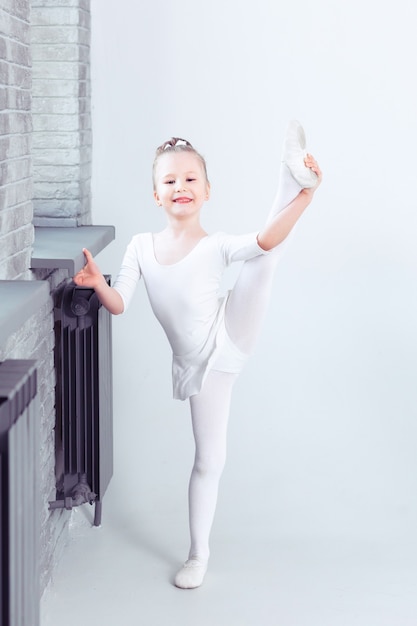 Niña linda sueña con convertirse en bailarina Niña en una ropa de baile blanca bailando