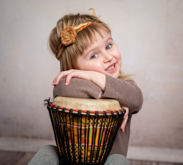 Niña linda tocando el tambor