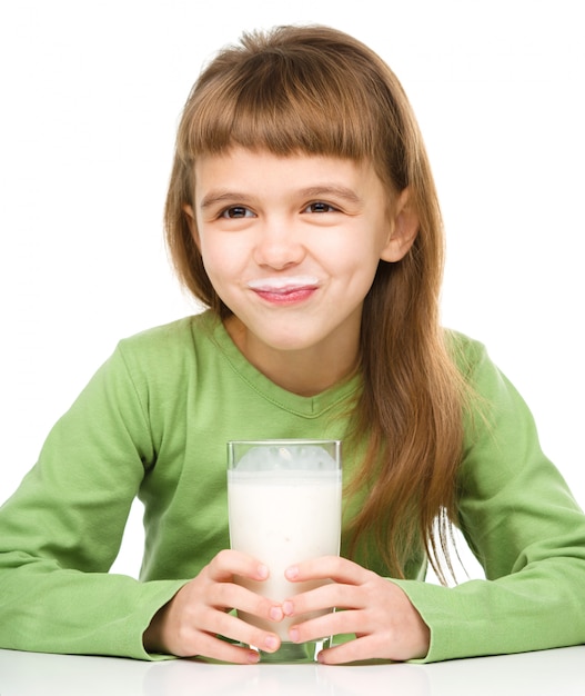 Niña linda con un vaso de leche