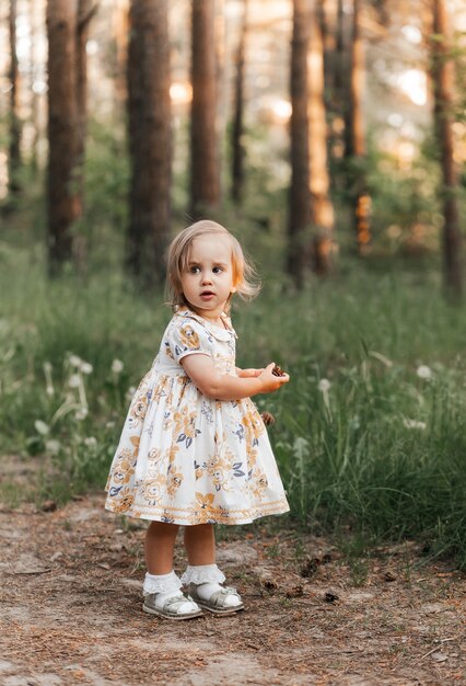 Niña de 3 años en un vestido de verano en el parque horario de verano